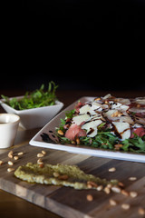 Arugula salad with parmezana cheese and raw meat black background