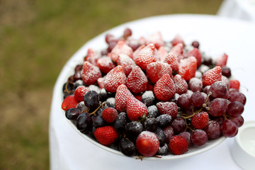 bowl of berries strawberries cherries grapes dusted with powdered sugar