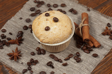 Tasty muffin cakes on burlap, spices and coffee beans