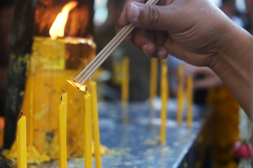 Joss stick and candle with hand