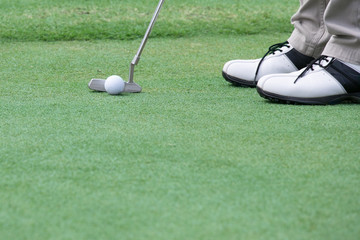 player putting golf ball on a green