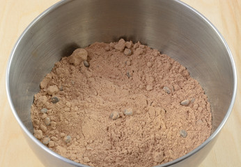 Close up of chocolate cake or brownie with chocolate chips in stainless steel mixing bowl