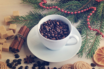 coffee beans poured into a mug at the Christmas backdrop from su
