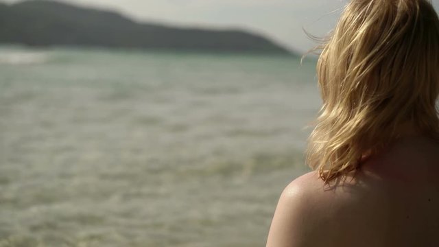 Young sexy woman sunbathing in sea or ocean