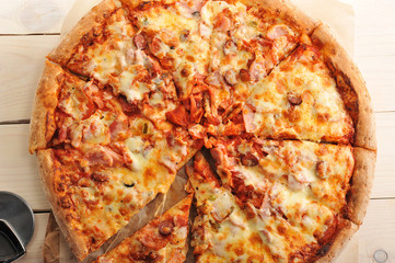 pizza with cheese and spicy sausage cut into slices