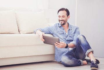 Cheerful man using tablet
