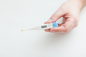 Hand holding electronic thermometer