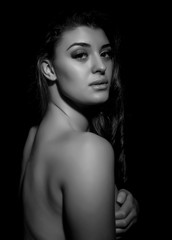 Naklejka premium silhouette of nude young beautiful woman on black background, black and white