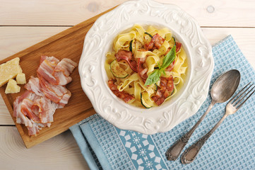 pasta with eggplant and bacon on the plate with Basil leaves