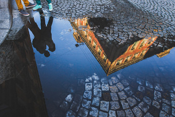 Silhouette hugging guy and girl in reflection in puddle on a street