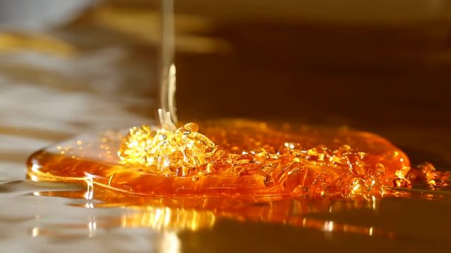 amber honey flowing on a gold background