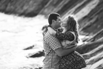 Young beautiful couple together near sea. Embrace, enjoy and kiss