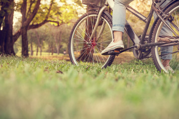 Fototapeta na wymiar Close up Young woman riding bike, blurred grass foreground. 