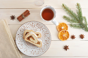 Christmas cake with powdered sugar, cut into slices, tea