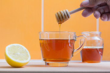 drop of honey into a glass of lemon tea