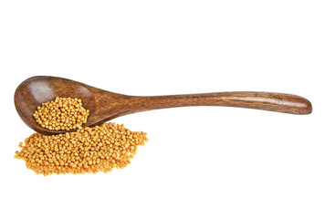 Yellow mustard seeds on wooden spoon isolated on white backgroun