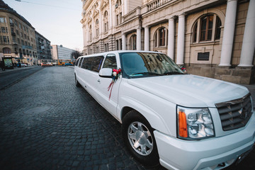 beautiful and glamorous wedding white limousine stands outdoors