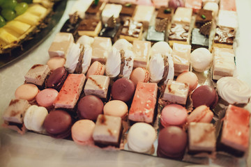 delicious colorful macaroons and cakes on the wedding candy bar