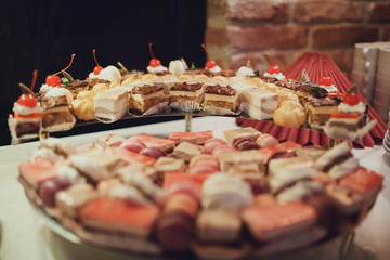 delicious colorful macaroons and cakes on the wedding candy bar