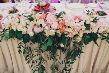 beautiful pink and white flowers on the table with green leafs
