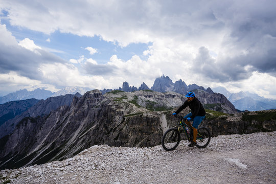 View of cyclist riding mountain bike on trail in Dolomites,Tre C
