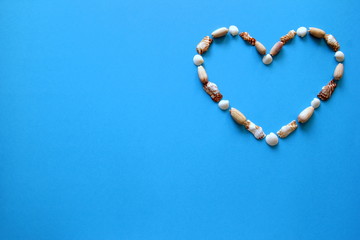 A heart from different seashells on the blue background for Valentine's Day.