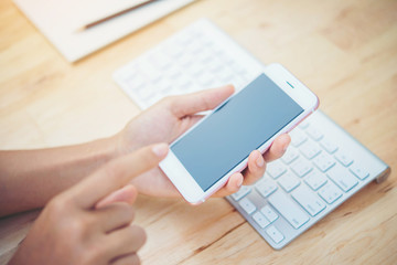 woman with cell phone and keyboard on wooden   table