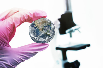 Concept study of the planet on the background of the microscope. Elements of this image furnished...