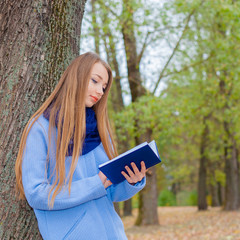 romantic dreamy girl reading a book outdoors