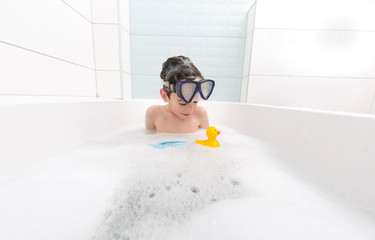 boy swims in the bathtub
