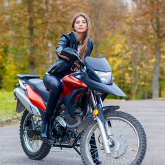 Naklejka na ściany i meble Portrait of a beautiful hipster girl on a sports motorcycle