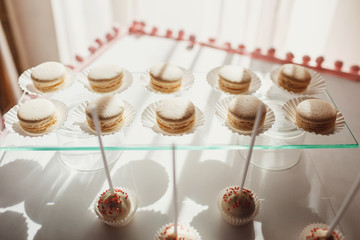 Morning light illuminates  white macaroons served on glass board