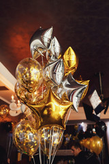 Golden and silver balloons in form of stars