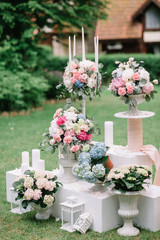 Bouquets of gorgeous peonies and roses stand on different tubes