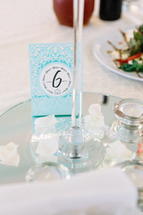 Blue card with number 6 stands on mirror tray in the centre of d