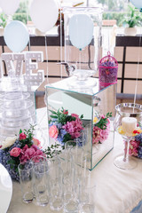 Empty glasses stand around mirror box with bird cages and flower