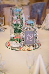 Frame with number 12 stands on mirror tray with flowers