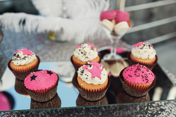Pink cupcakes with glaze stars served on square mirror tray