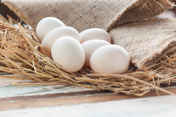 Organic white eggs on vintage wooden background.