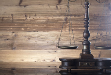 Obraz na płótnie Canvas Law and justice concept. Scales of justice, gavel, paragraphs, brown wooden background, place for text