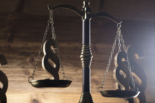 Law and justice concept. Scales of justice, gavel, paragraphs, brown wooden background, place for text