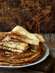 Fried crepes on the plate. Russian pancakes. View from side. Selective focus