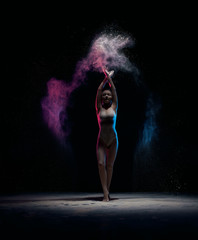 Obraz na płótnie Canvas Slender girl posing in color powder cloud