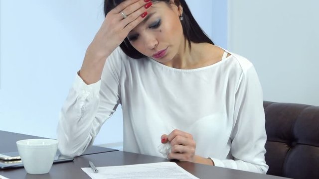 Young busy woman feeling not well but continuing signing papers