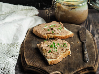 Fresh homemade chicken liver pate on toast with vegetables homemade bread on a brown board
