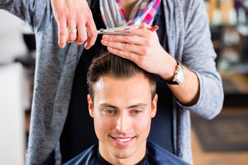 Friseur schneidet Mann die Haare im Friseursalon 