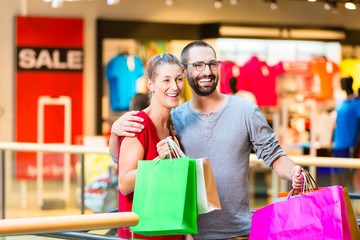 Mann und Frau in Kaufhaus mit Einkaufstüten