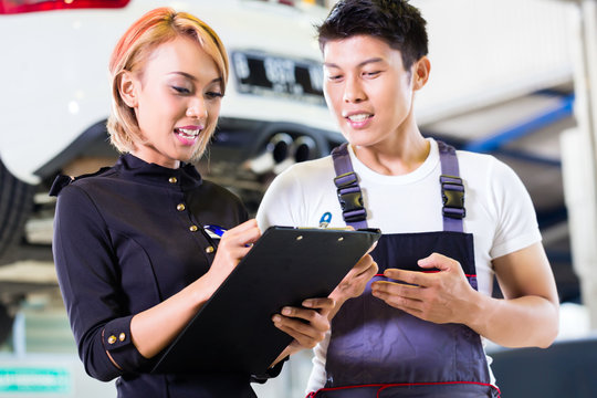 Asian Car mechanic and manager assigning tasks