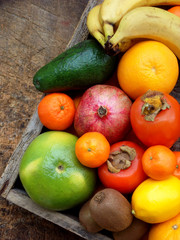 Composition of mix colored tropical and mediterranean fruits on wooden background. Concepts about decoration, healthy eating