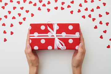 Red dotted long gift box with white ribbon on white background.